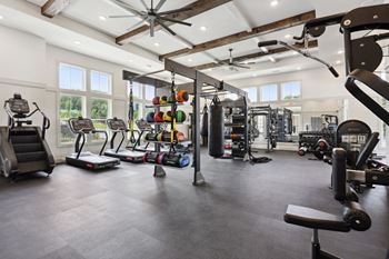 A spacious gym with a variety of equipment including treadmills, weights, and a bench press
